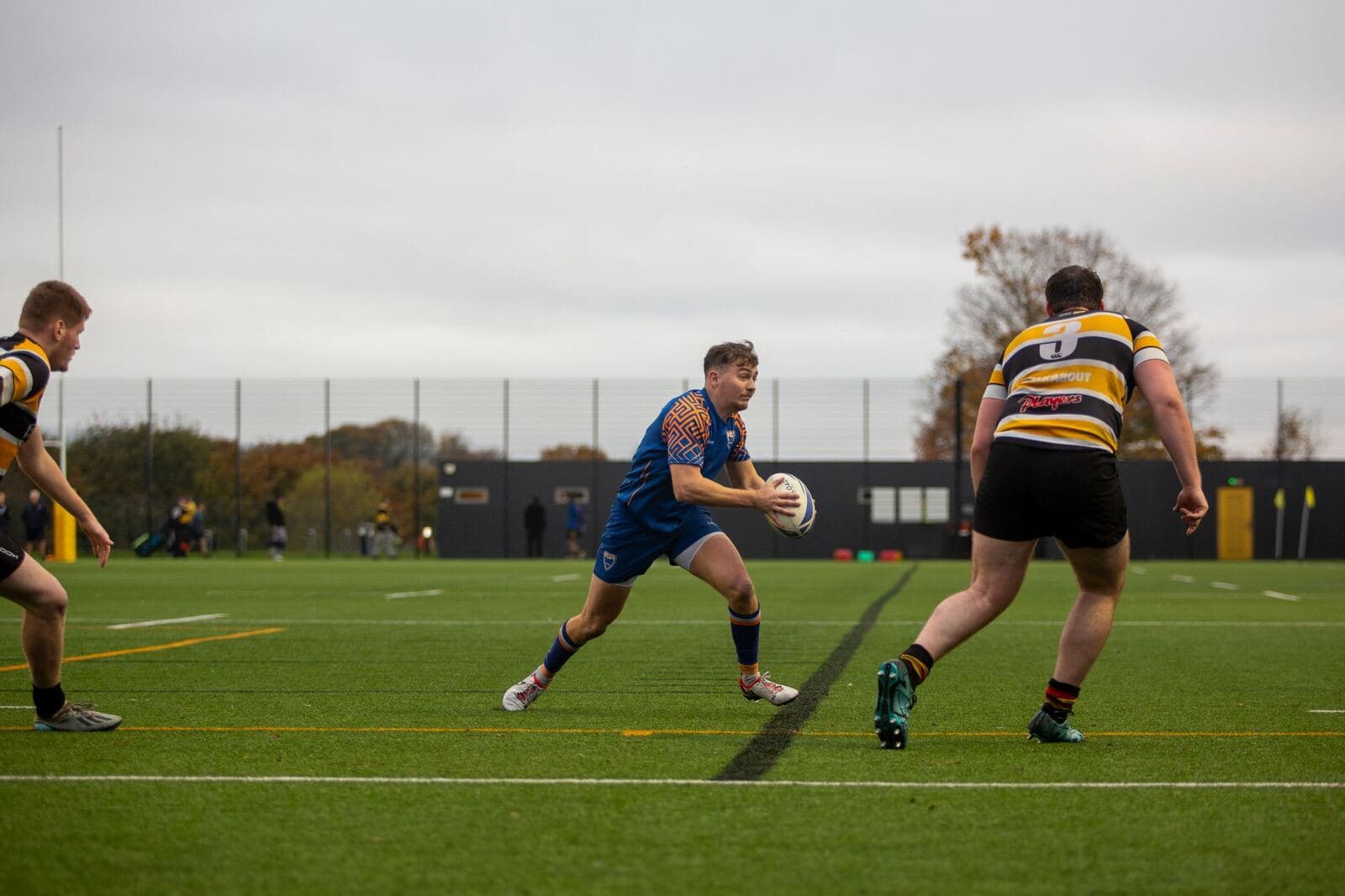 Rugby players training with a ball on a grass field